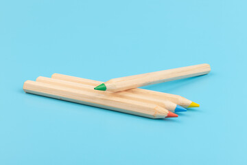 Obraz premium Wooden colorful ordinary pencils isolated on blue background. Back to school