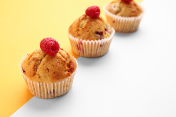 Tasty raspberry muffins on color background, closeup
