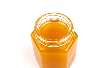 Glass jar full of sweet honey isolated on white background