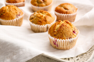 Tray with tasty raspberry muffins on light background, closeup