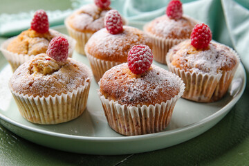 Tray with tasty raspberry muffins on color wooden background, closeup