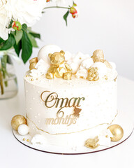 Cake white cream decorated with a bear of gold color close-up