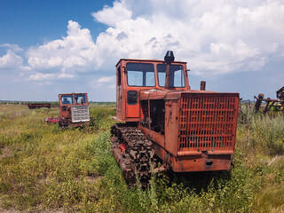 Old agricultural tractors are abandoned in the open.