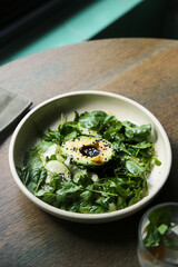 Healthy green salad with avocado and sesame dressing