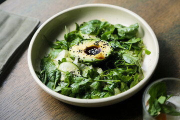 Healthy green salad with avocado and sesame dressing