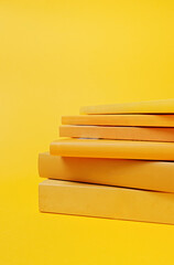 Stack of yellow books on yellow background. Education concept. - obrazy, fototapety, plakaty