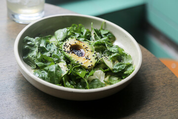 Healthy green salad with avocado and sesame dressing
