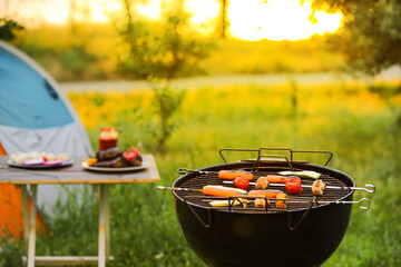 Barbecue grill with tasty sausages and vegetables outdoors