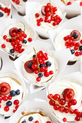 Summer cupcakes are decorated with white cream and berries