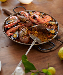 Delicious seafood paella in pan on rustic table