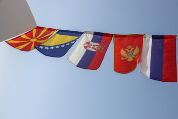 Flags of Balkan Countries And Russia Swaying Together Against The Blue Sky