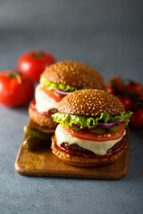 Traditional homemade cheeseburgers with pickles