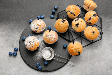 Composition with tasty blueberry muffins and berries on black and white background