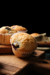 Tasty blueberry muffins on dark background, closeup
