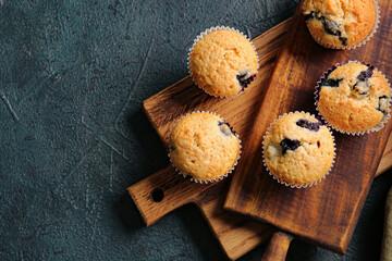 Obraz na płótnie Canvas Tasty blueberry muffins on dark background, closeup