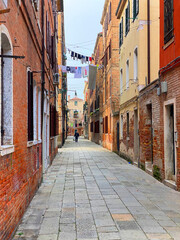Colorful dead end street in Venice with lots of laundry hanging out to dry in lines stretched between the houses