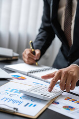 A male accountant or a business man uses a laptop to calculate investment results. And making...