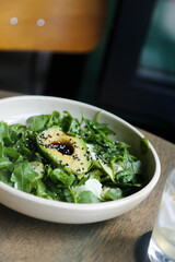 Healthy green salad with avocado and sesame dressing