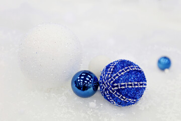 Blue Christmas balls on white snow background. New Year toys, decorations for greeting card