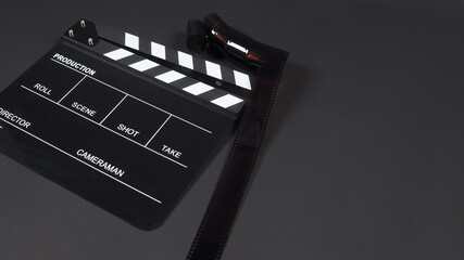 Fototapeta na wymiar Film roll with Clapperboard or movie slate use in video production, cinema industry on black background.