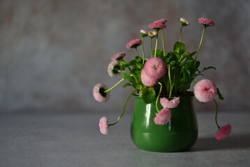Bouquet of pink daisies in a green mug.