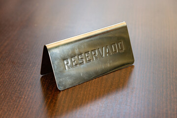 Cartel de reservado en una mesa de bar para clientes por restriciones de Covid