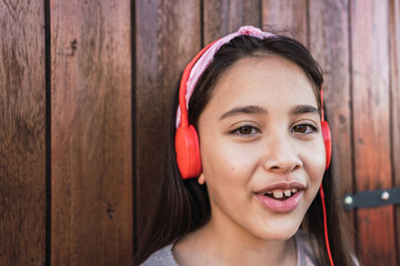 Portrait of a cute little girl with red headphones.