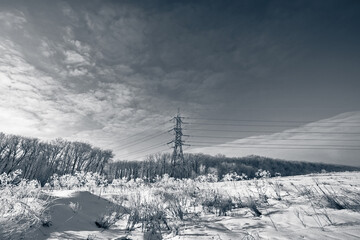 Long lines of power line towers stretching across a Winter Landscape.