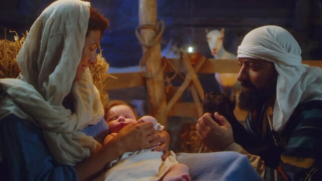 Joseph with lamb and Mary with baby Jesus in stable nativity scene