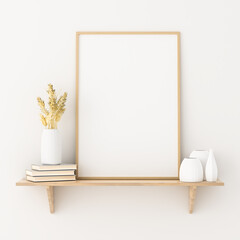 Empty picture frame mockup on a shelf with books, porcelain vases and dried wheat ears.
