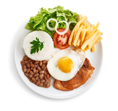 Prato executivo de bisteca su&iacute;na com ovo frito, arroz, feij&atilde;o, salada e batatas fritas, visto de cima e isolado com path