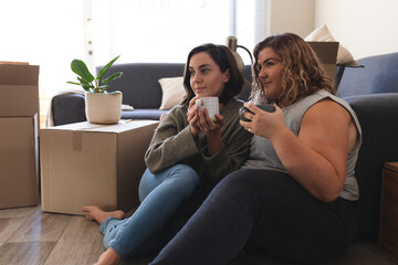 Lesbian couple moving house sitting and drinking tea