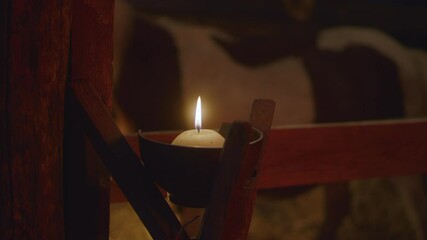 Candle illuminating stable on Christmas day nativity