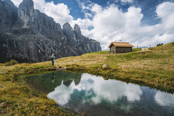 Fototapeta na wymiar Woman enjoying Passo Gardena and Sella group mountains in Dolomites, south Tyrol, Italy, Europe