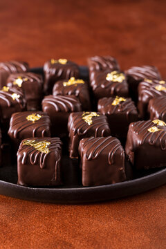 Dark chocolate homemade truffles and pralines decorated with edible gold