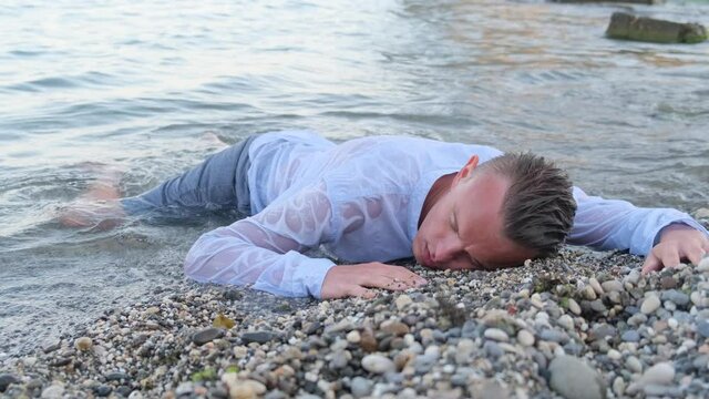 A man who swam out after a storm lies unconscious on the seashore