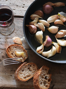 Pan-fried cloves of garlic with baguette bread
