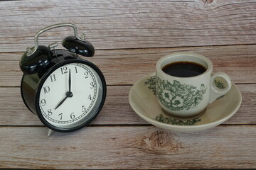 Fototapeta na wymiar a cup of black coffee with alarm clock