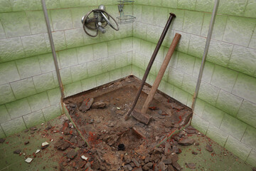 Old bathtub and tiles demolish, tilt hammer and crowbar in a ruined  bathroom