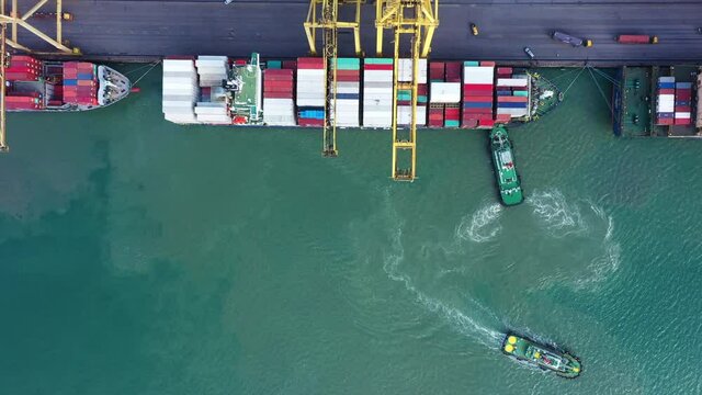 Aerial view of cargo container ship drage by tug boat to international terminal yard port  concept freight shipping by ship