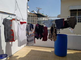 The view of newly washed clothes that were dried on a clothesline located on top of the middle low...