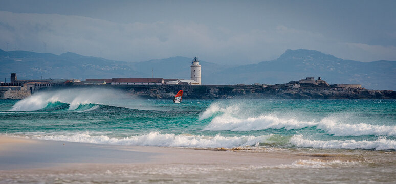 Person kitesurfing in front of lighthouse, Tarifa, Cadiz, Andalusia, Spain