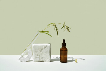 CBD oil in brown bottle with dropper and cannabis, hemp branch