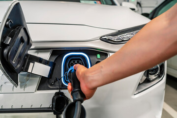 young man charging his non-polluting electric vehicle