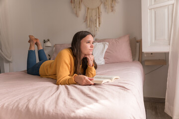 girl lying in bed with a book