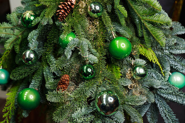 Close-up view of beautiful christmas tree with colorful baubles and illuminated garland. Fir tree decorated with christmas balls over red brick wall . Sparkling and fairy background. New year holiday - Powered by Adobe