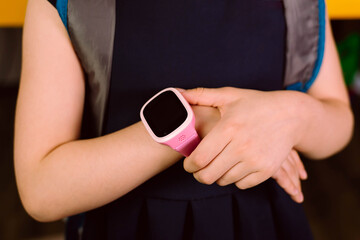 Children's smart watches are pink in color isolated on a yellow background. Technology, communication, control concept.