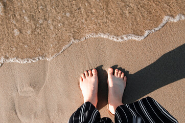 Woman's feet on the sand on the beach