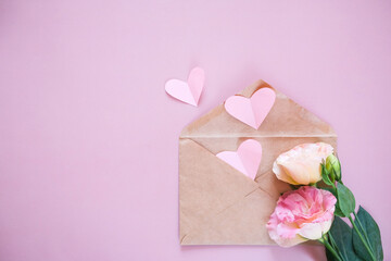 Creative minimal Valentine's Day concept. Envelope, valentines, white and pink heart confetti on a pastel pink background. Flat lay, top view, copy space
