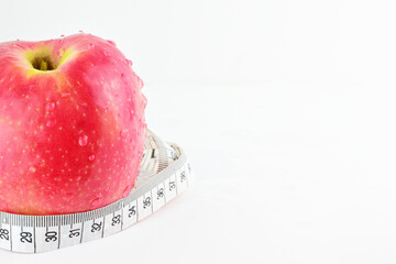 Red apple with measuring tape, isolated on white background. Concept, healthy eating, keep the line. Copy space.